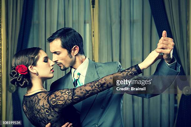 young couple dancing tango in room - tango stockfoto's en -beelden