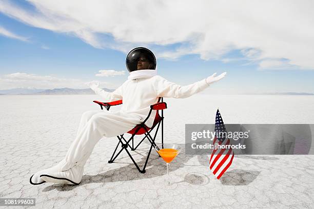 astronauta seduto in una sedia da giardino - astronauta bandiera foto e immagini stock