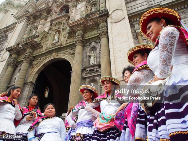 Group of indigenous girls, wearing typical costumes, standing up in front of the cathedral when hundreds of Quechua-speaking Indigenous people,...