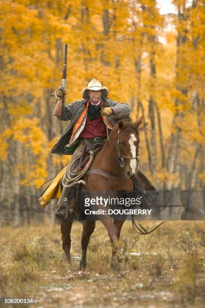 cowboy equitazione in autunno - cowboy gun foto e immagini stock