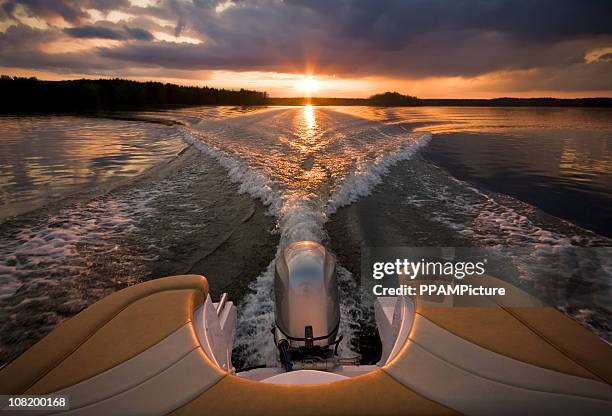 bei sonnenuntergang - schnellboot stock-fotos und bilder