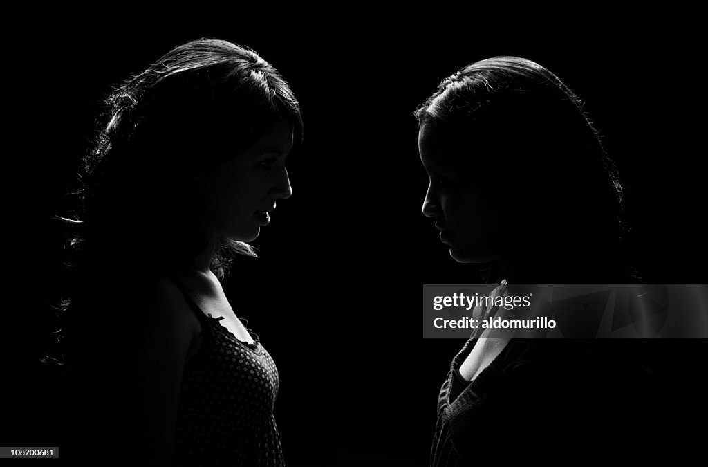 Low Key Lit Portrait of Two Woman Facing Each Other