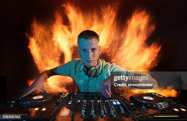 dj at turntables with fire in background - dj decks stock pictures, royalty-free photos & images