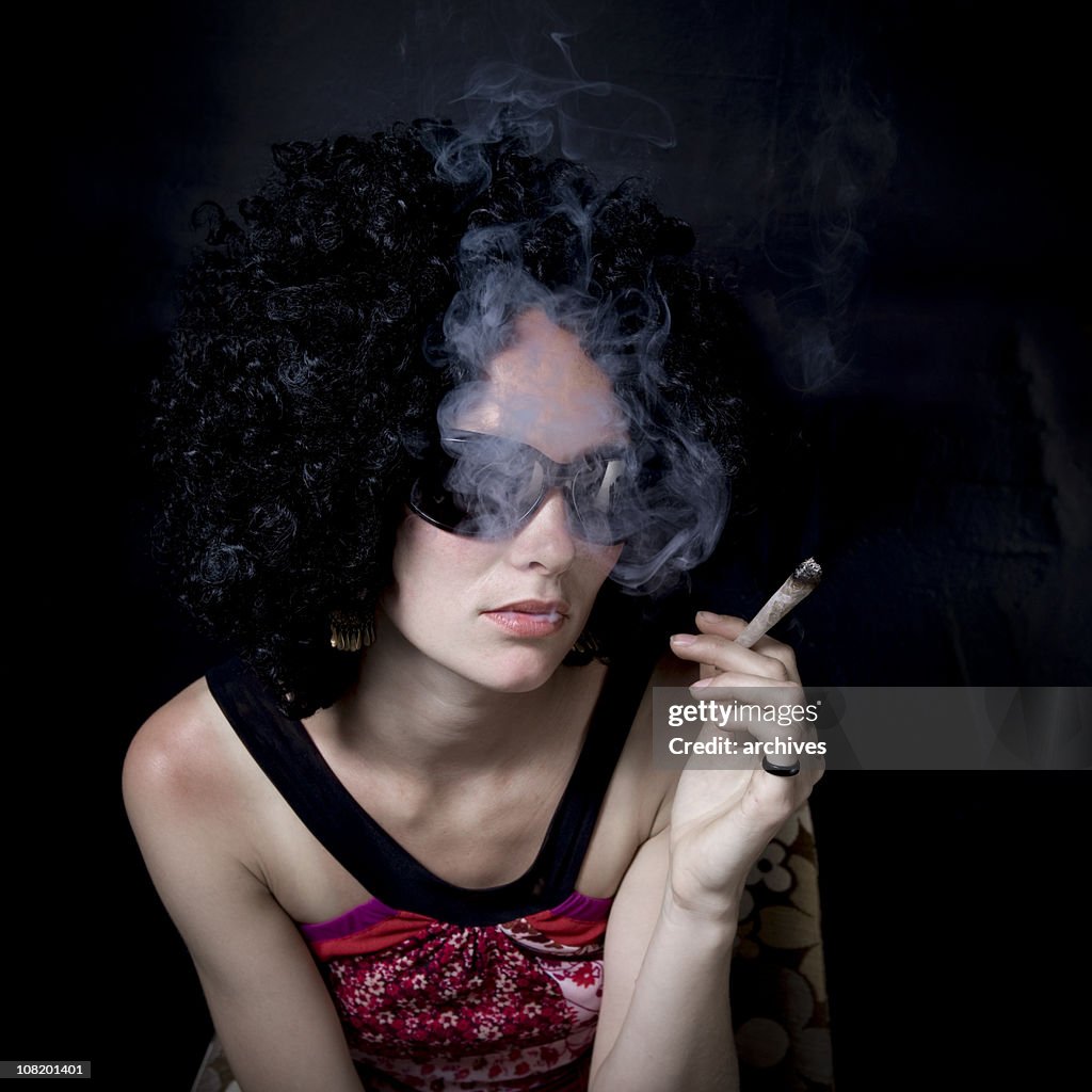 Jovem mulher fumar Maconha em fundo preto