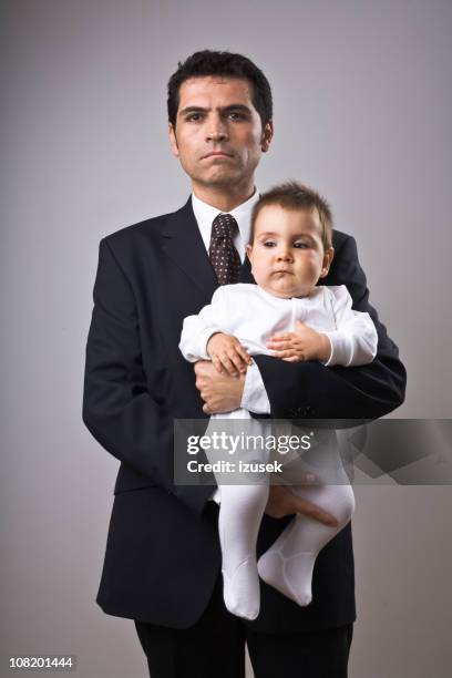 businessman holding baby - lege uitdrukking stockfoto's en -beelden