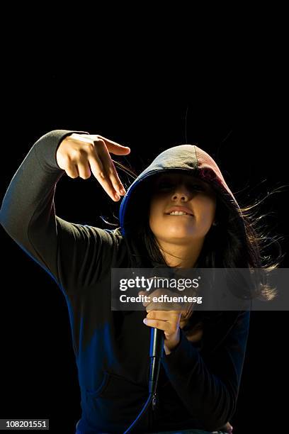 portrait of young woman wearing hood and holding microphone - woman rap stock pictures, royalty-free photos & images