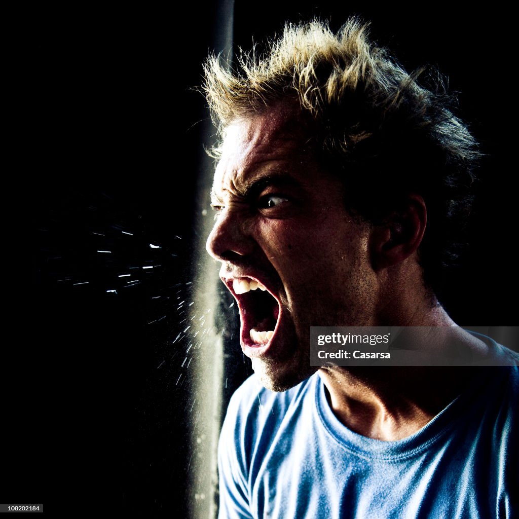 Wütend junger Mann mit schreien und Spucken