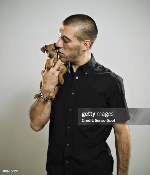 young man kissing puppy - mods stockfoto's en -beelden