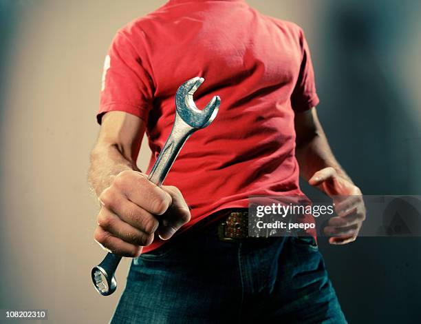 man in red shirt holding wrench - open end spanner stock pictures, royalty-free photos & images