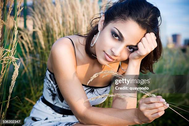 modèle belle jeune femme hispanique à l'extérieur de l'hôtel dans le champ au crépuscule - hoop earring photos et images de collection