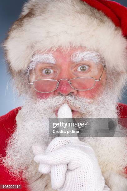 santa holding finger auf den mund legen - buschig stock-fotos und bilder