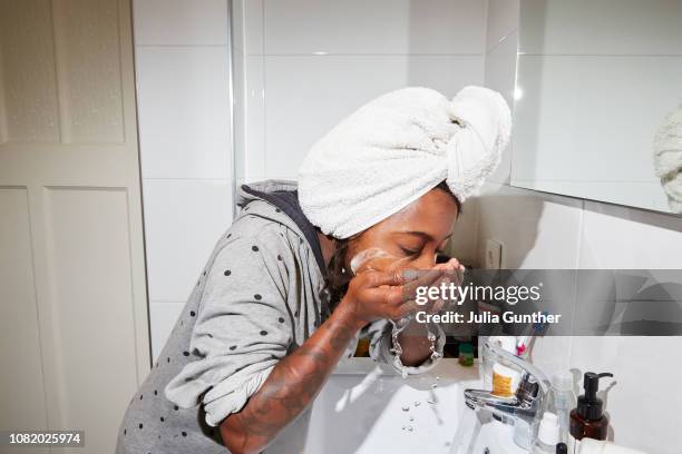woman washes her face - gesichtsreinigung stock-fotos und bilder
