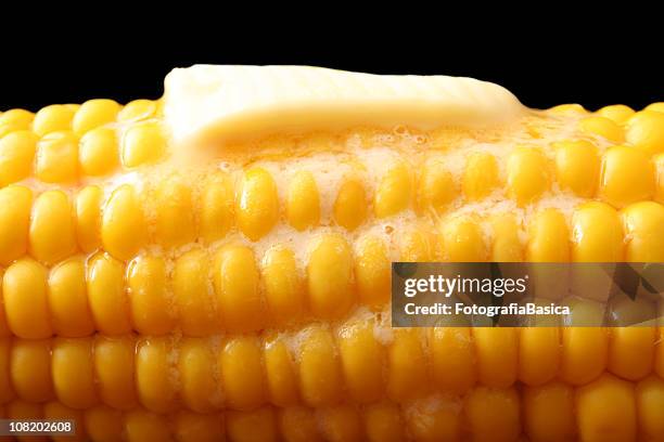 butter slice melting on hot corn, - corn on black stockfoto's en -beelden
