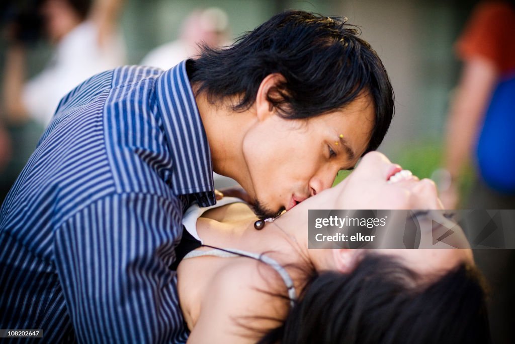 Uomo Baciare la donna Giovane asiatica sul collo