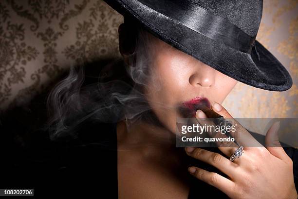 asian gangster woman in fedora smoking cigar with diamond ring - female gangster stock pictures, royalty-free photos & images