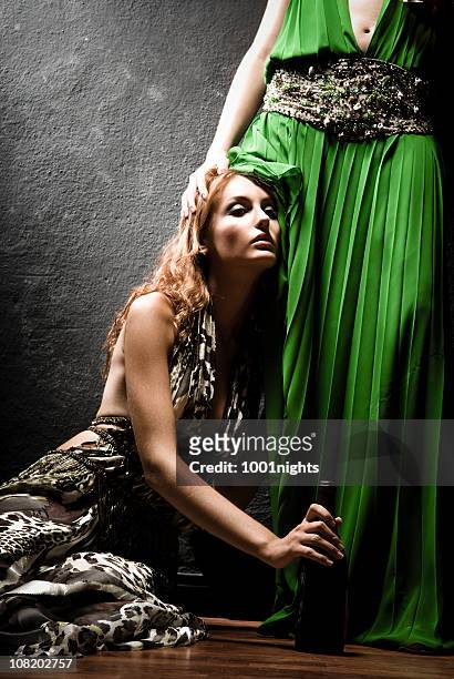 woman in long dress kneeling and leaning head against person - long dress stock pictures, royalty-free photos & images