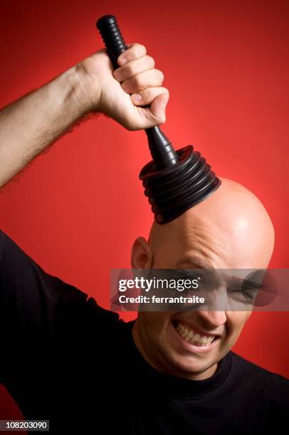 man trying to pull plunger off head - plunger stock pictures, royalty-free photos & images