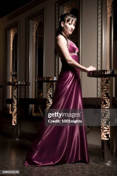 young woman in long dress resting hands on nightclub table - long dress party stock pictures, royalty-free photos & images