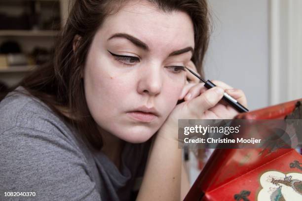 young adult putting on eyeliner - showus makeup stock pictures, royalty-free photos & images