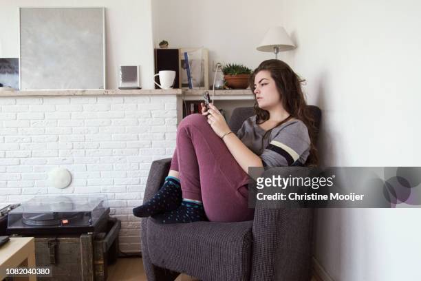 young adult woman using a smartphone - pantaloni di tuta foto e immagini stock