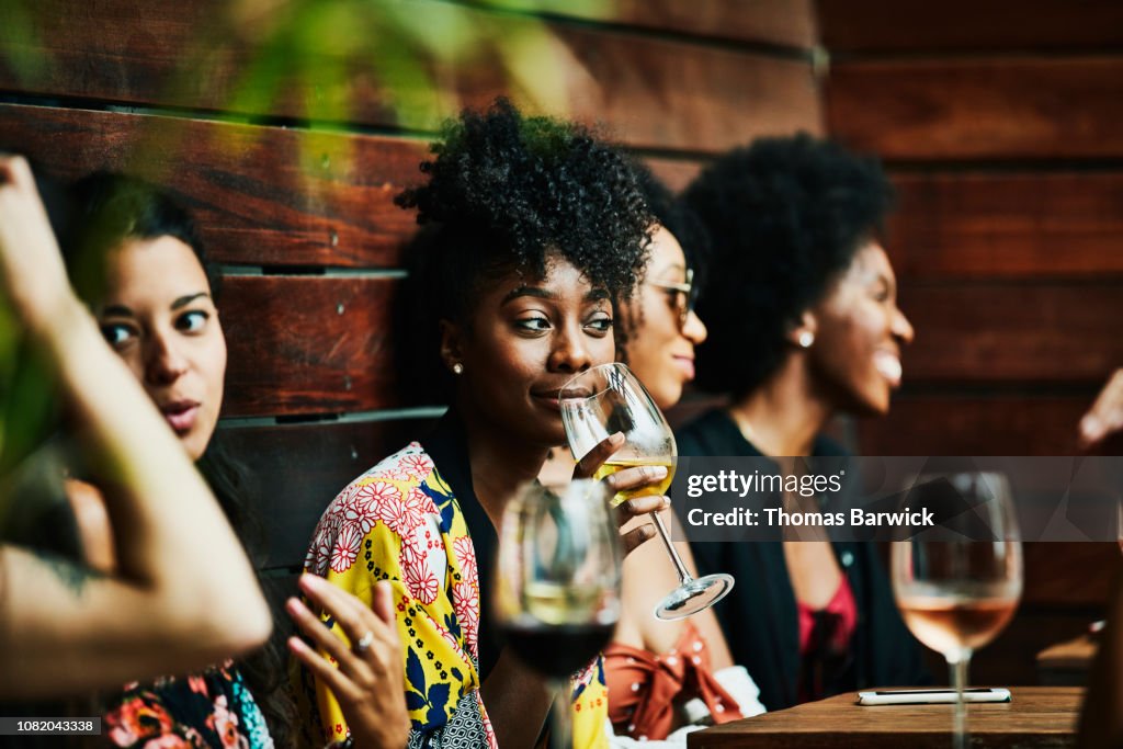 Woman enjoying drink with friends at poolside bar