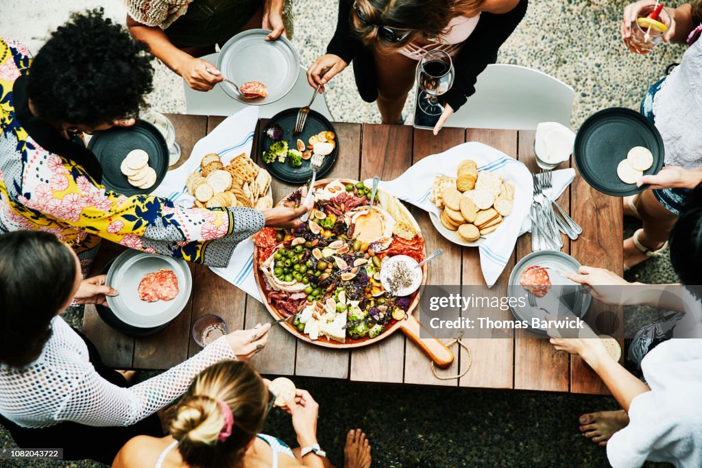 Overhead view of group of friends enjoying buffet of food during party
