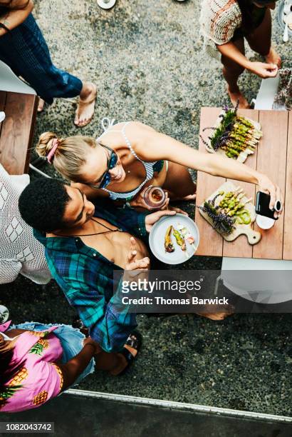 overhead view of friends taking selfie with smart phone during pool party - sunglasses overhead fotografías e imágenes de stock