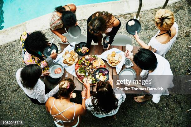 overhead view of friends sharing food during pool party at hotel - pool table stock-fotos und bilder