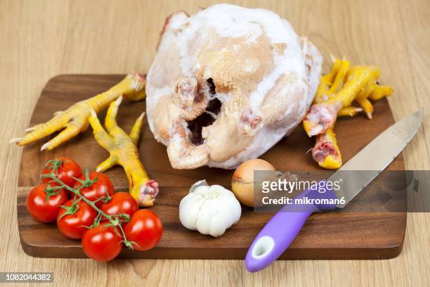 frozen, raw, organic chicken on chopping board with vegetables - offal stock pictures, royalty-free photos & images
