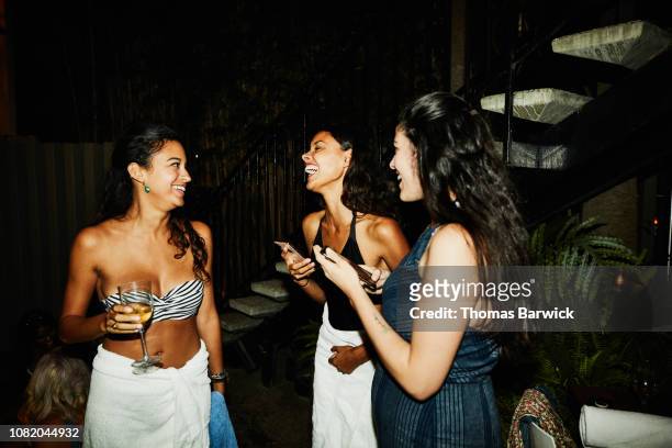 laughing friends in discussion during party at hotel pool - pool party night stock pictures, royalty-free photos & images