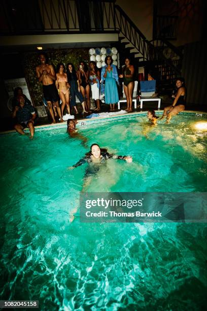 woman in dress swimming in hotel pool after falling in during party - pool party night stock pictures, royalty-free photos & images