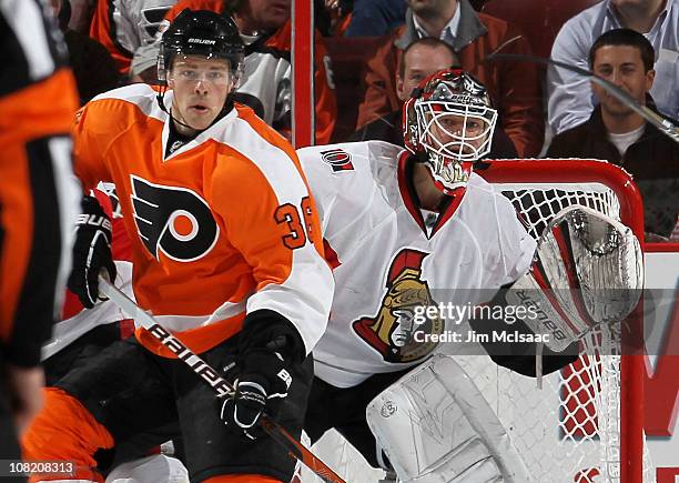 Brian Elliot of the Ottawa Senators defends against Darroll Powe of the Philadelphia Flyers on January 20, 2011 at Wells Fargo Center in...