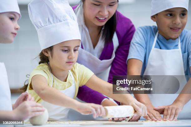 little girl rolling dough - children cooking school stock pictures, royalty-free photos & images