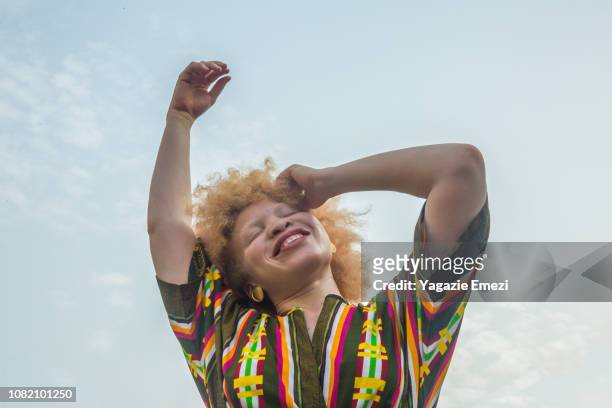 Woman smiling against sky.