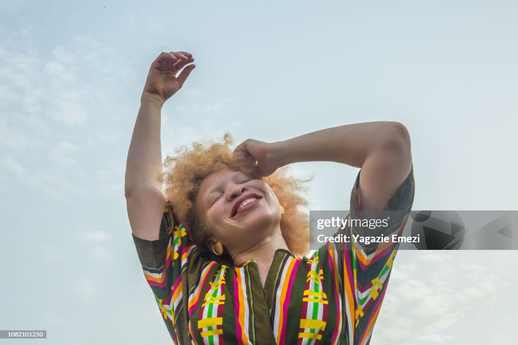 Woman smiling against sky.