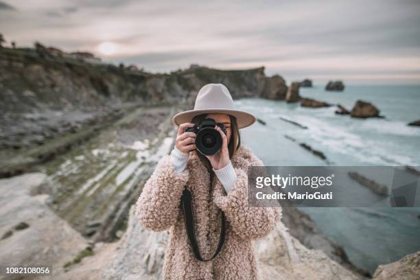 jonge vrouw nemen van een foto met een moderne dslr camera - spiegelreflexcamera stockfoto's en -beelden