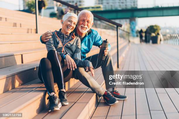 ouder paar ontspannen na het werk uit - fitness armband stockfoto's en -beelden