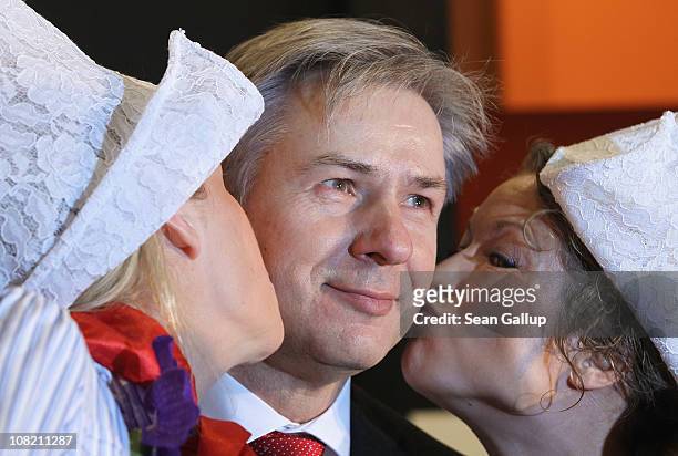 Berlin city mayor Klaus Wowereit gets a kiss at a Dutch foods and agricultural stand while touring the 2011 Gruene Woche international agricultural...