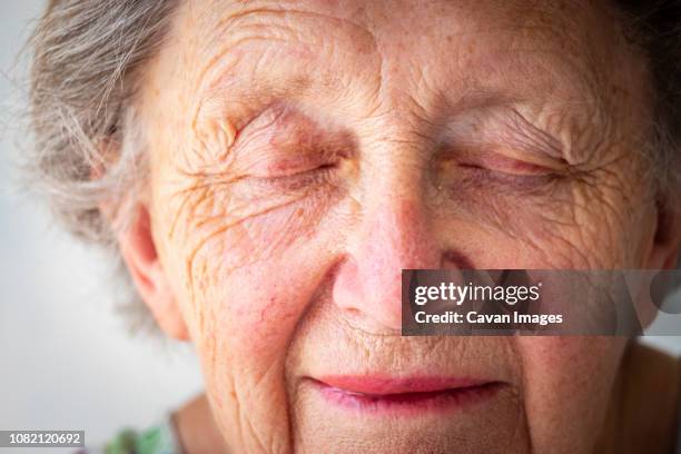 close-up of sad senior woman with eyes closed - endast en pensionärskvinna bildbanksfoton och bilder