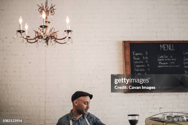 male owner standing against wall in cafe - hanging board stock pictures, royalty-free photos & images