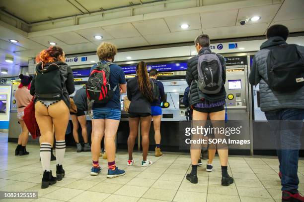 Participants are seen at the ticket machine purchasing their travel tickets at the Paddington underground station during the 10th anniversary of No...