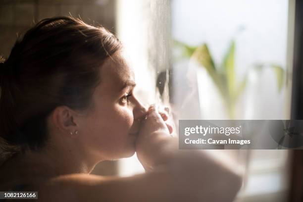 close-up of pregnant woman in labor at home by window - home birth stock-fotos und bilder