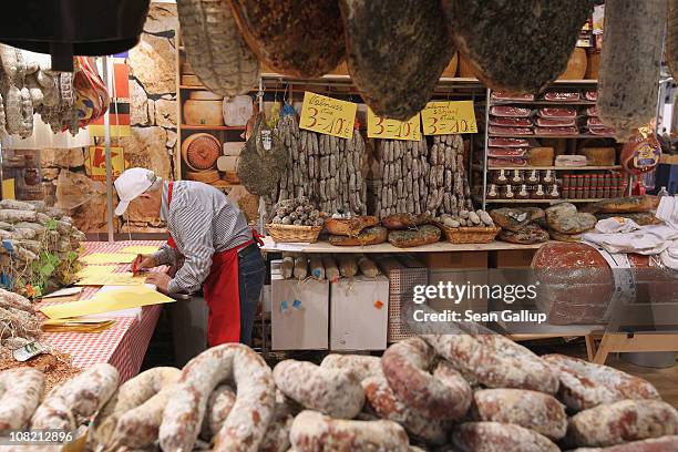 Stand worker prepares signs among dried meats and sausages at a South Tirol meats stand at the 2011 Gruene Woche agricultural trade fair at Messe...