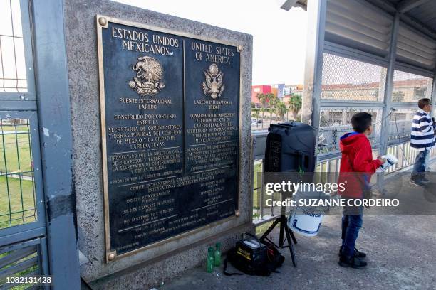 Man speaks into a microphone on the International Bridge on the US/Mexico border in Laredo, Texas, on January 13, 2019.