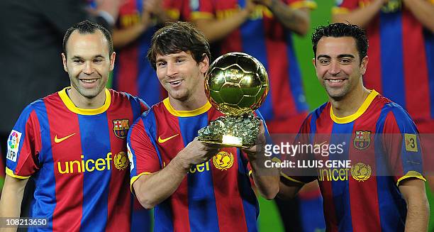 Barcelona's Argentinian forward Lionel Messi , flanked with Barcelona's midfielder Xavi Hernandez and Barcelona's midfielder Andres Iniesta , poses...