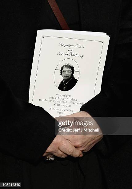 Mourner holds a order of service at the funeral of Scottish singer songwriter Gerry Rafferty at St Mirren Cathedral on January 21, 2011 in Paisley,...