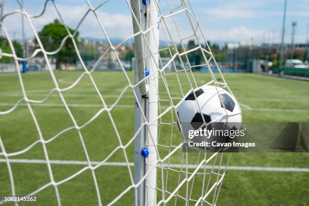 soccer ball hitting net against sky - football field foto e immagini stock