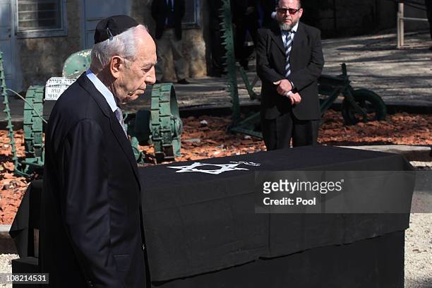 Israeli President Shimon Peres walks past the coffin of his late wife Sonia, during her funeral ceremony on January 21, 2011 in Ben Shemen, Israel....
