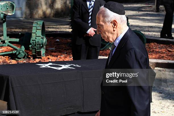 Israeli President Shimon Peres walks past the coffin of his late wife Sonia, during her funeral ceremony on January 21, 2011 in Ben Shemen, Israel....