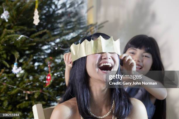 mother & daughter laughing - paper crown christmas stock pictures, royalty-free photos & images